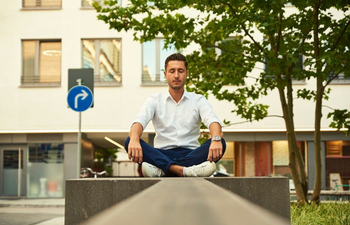 man in white dress shirt sitting on gray concrete bench during daytime