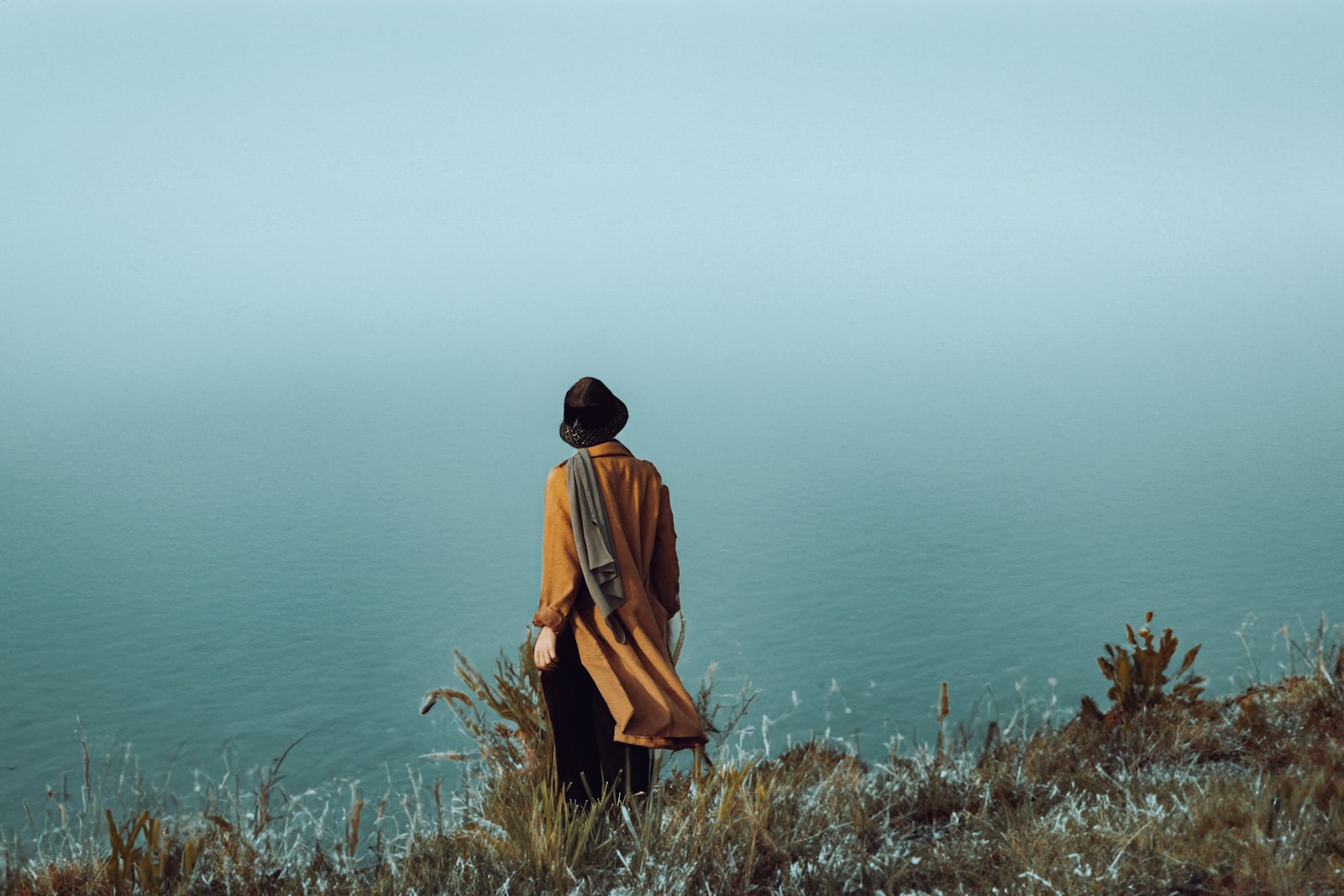 a person standing on a hill overlooking a body of water