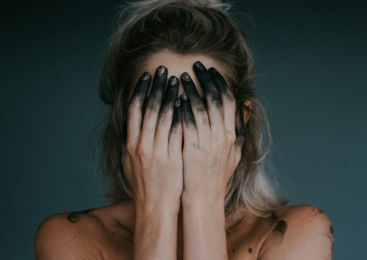 woman covering face with both hands closeup photography